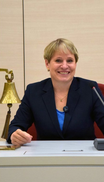 Eva Linhart mit Sitzungsglocke am Schreibtisch im Stadtrat