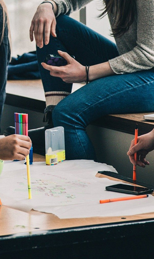 Schülerinnen sitzen im Klassenzimmer um einen Tisch